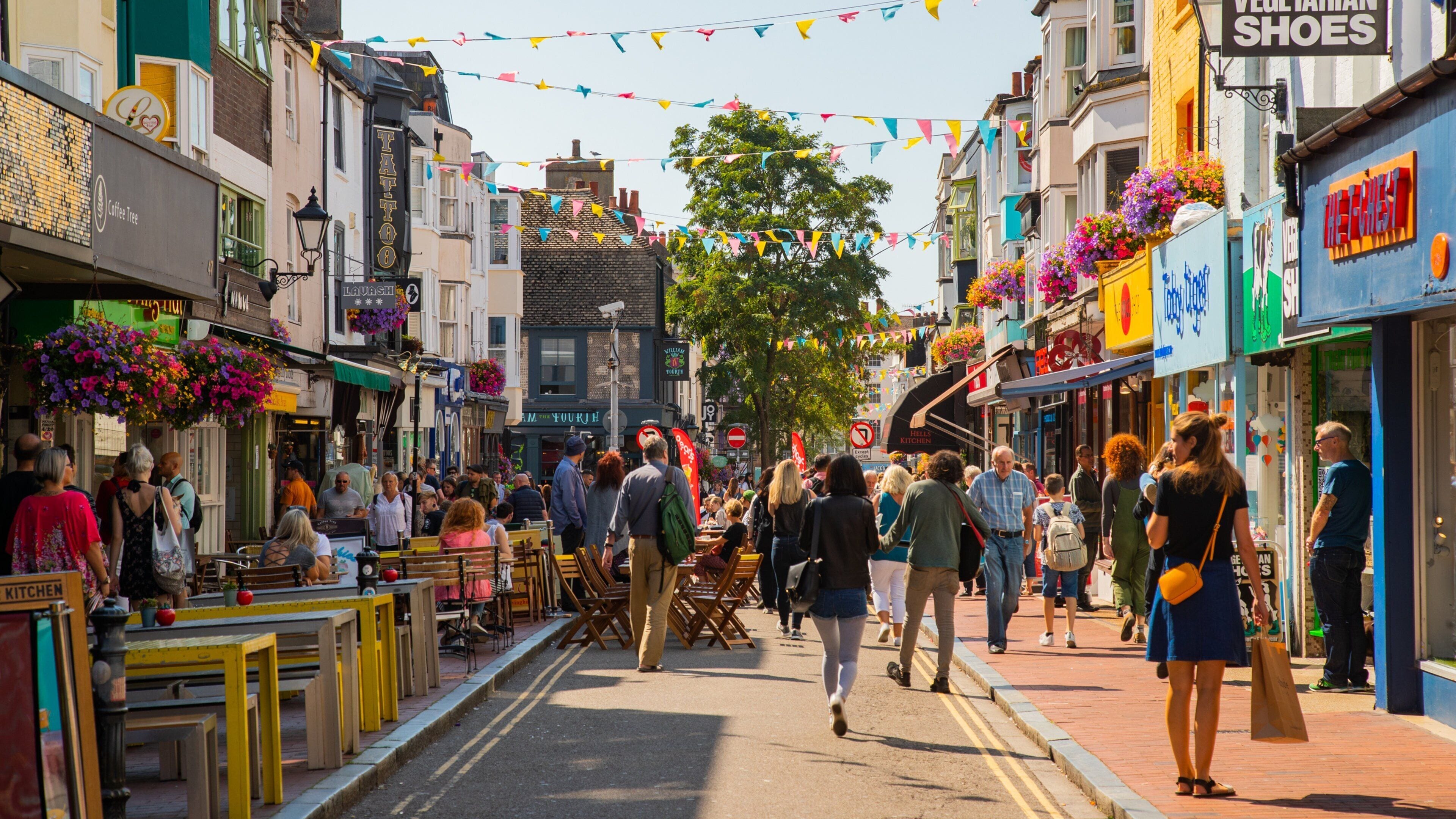 A bustling street lined with cafes, shops, and colorful decorations.