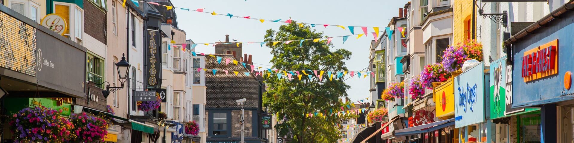 A bustling street lined with cafes, shops, and colorful decorations.