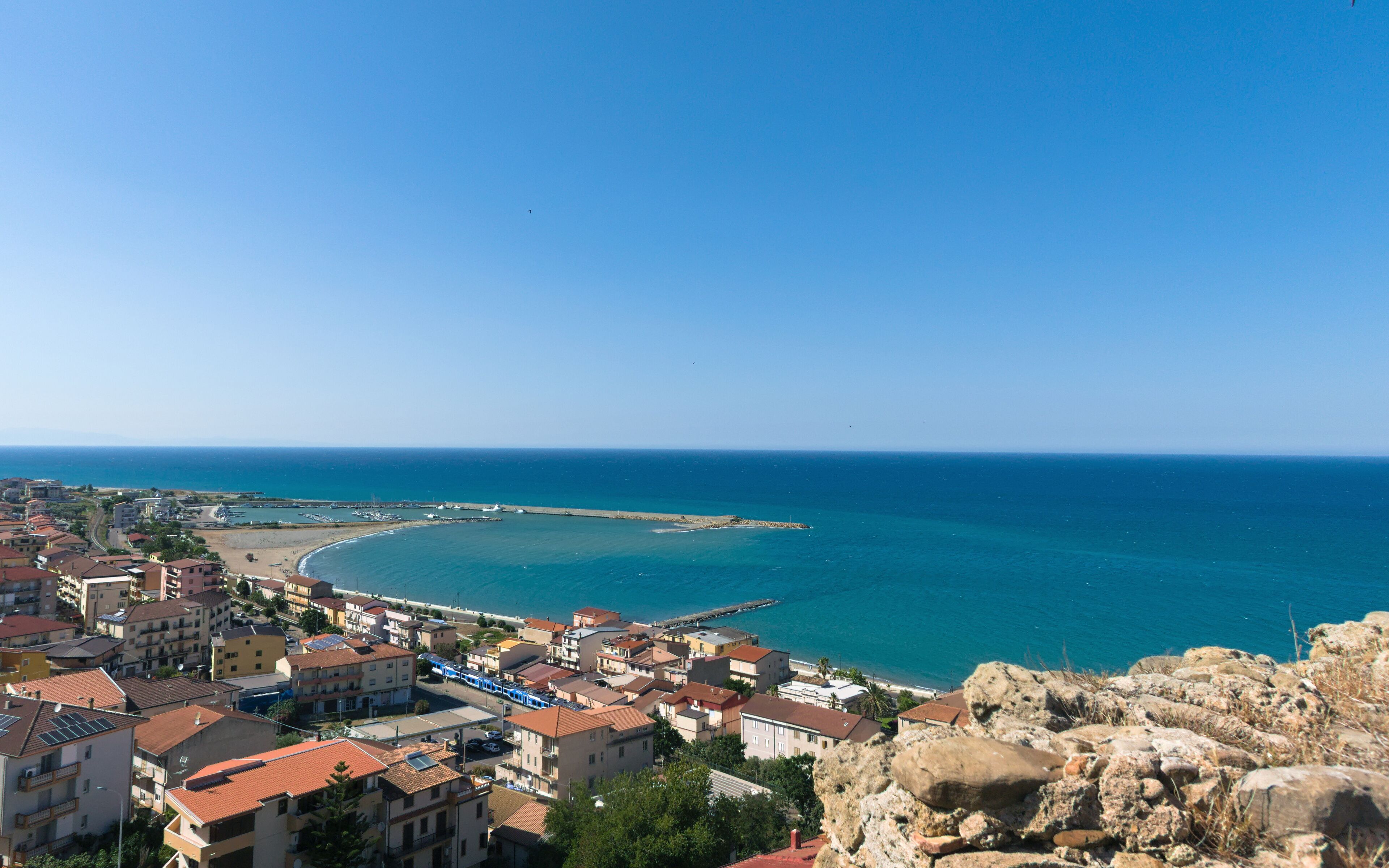 A coastal town with buildings, a pier, and the sea.