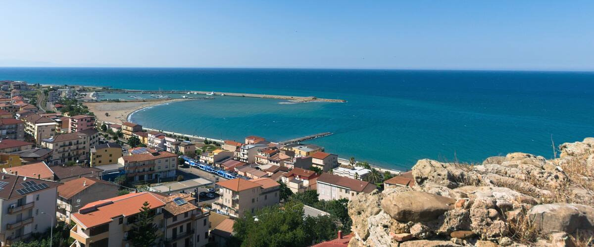 A coastal town with buildings, a pier, and the sea.
