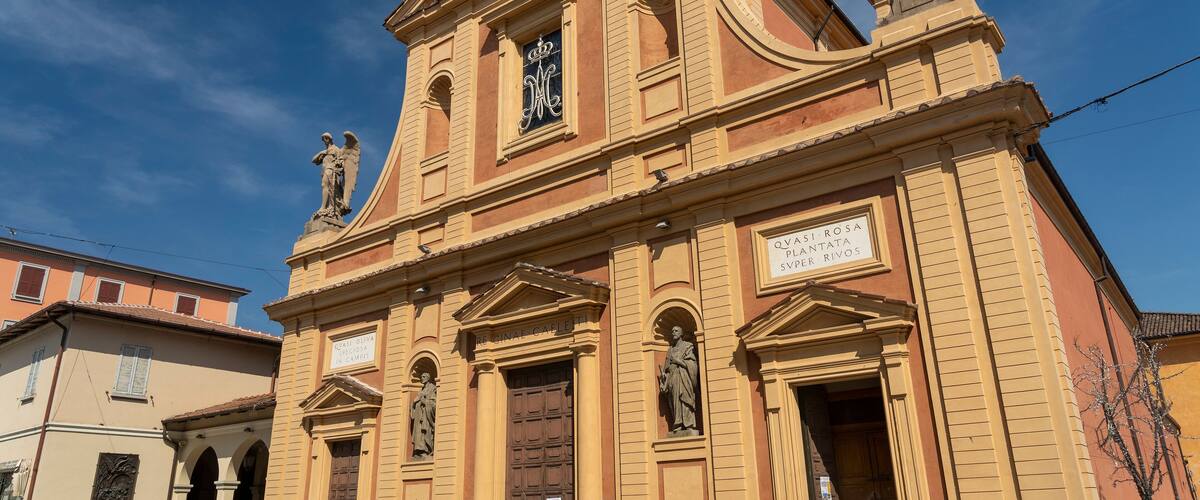A historic church with statues and a sign reading "Quasi Rosa Santuario di Caravita".