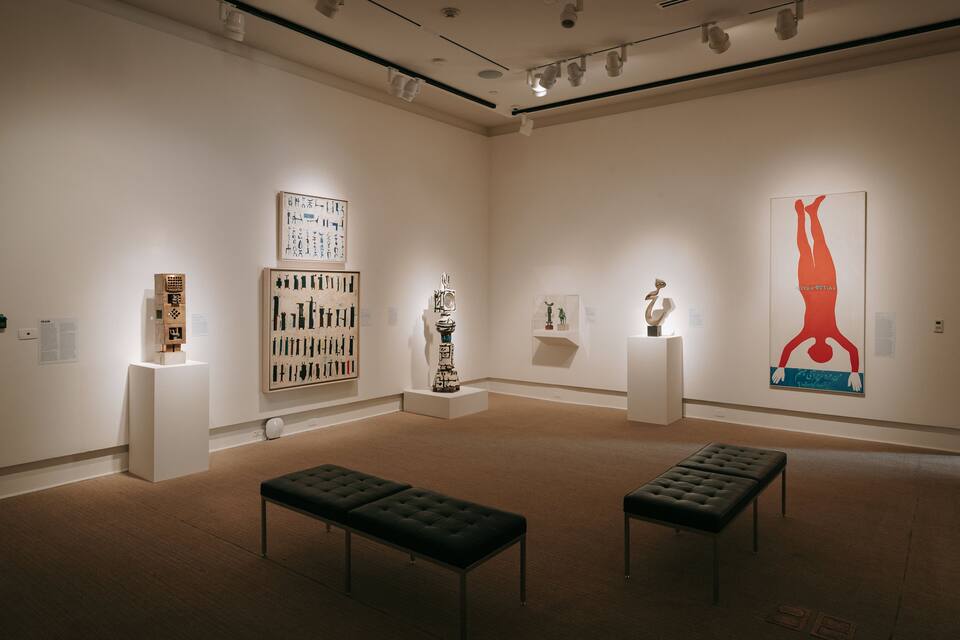 Een kunstgalerie met verschillende sculpturen en schilderijen.