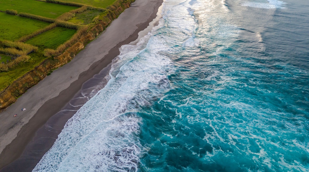 Santa Barbara beach with volcanic sand and turquoise Atlantic ocean waves in Sao Miguel, Azores. Aerial drone view of coast in Ribeira Grande town