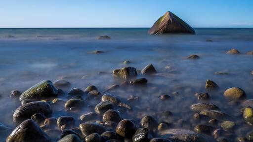 The so-called Schwanenstein, a glacial erratic near the village of Lohme on the island of Rรผgen, Germany. On 13 February 1956, three boys from the village of Lohme were playing by the shore of the frozen sea. The weather changed suddenly, and a storm broke the ice. The boys saved themselves by climbing onto the stone. As the wind turned into a hurricane, local fishermen and border guards tried to save the boys but they failed as the storm was too heavy. The next morning when the weather had calmed, the bodies of the three boys were recovered from the stone.