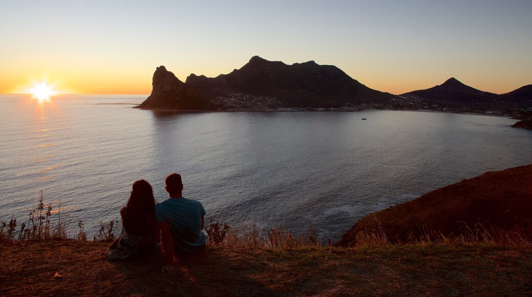 Chapmans Peak showing a sunset and rugged coastline as well as a couple