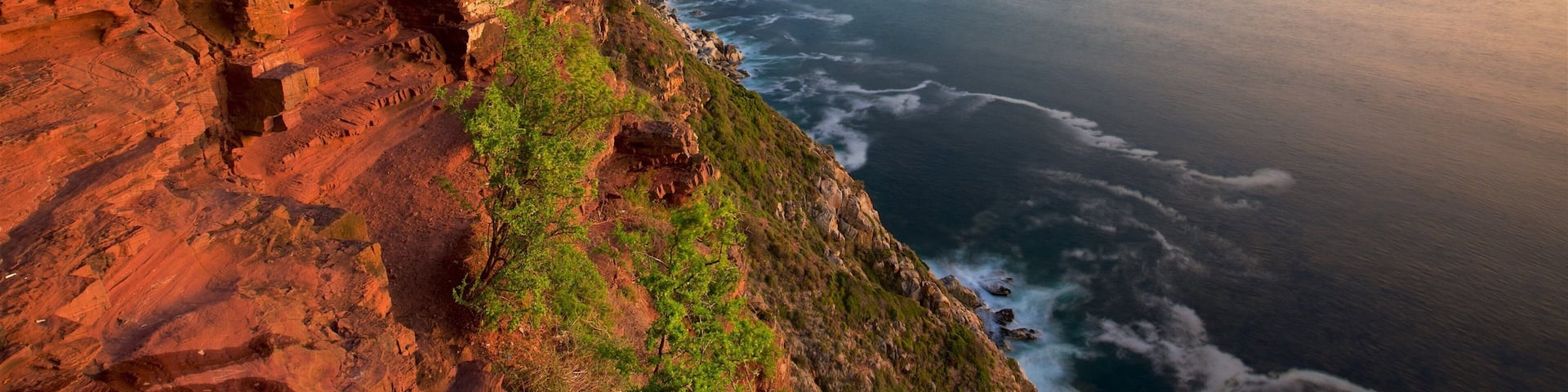 Chapmans Peak showing rocky coastline and a sunset