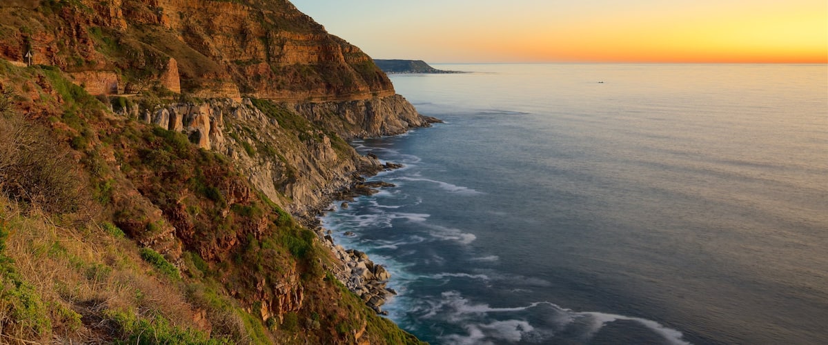 Chapmans Peak featuring a sunset and rugged coastline