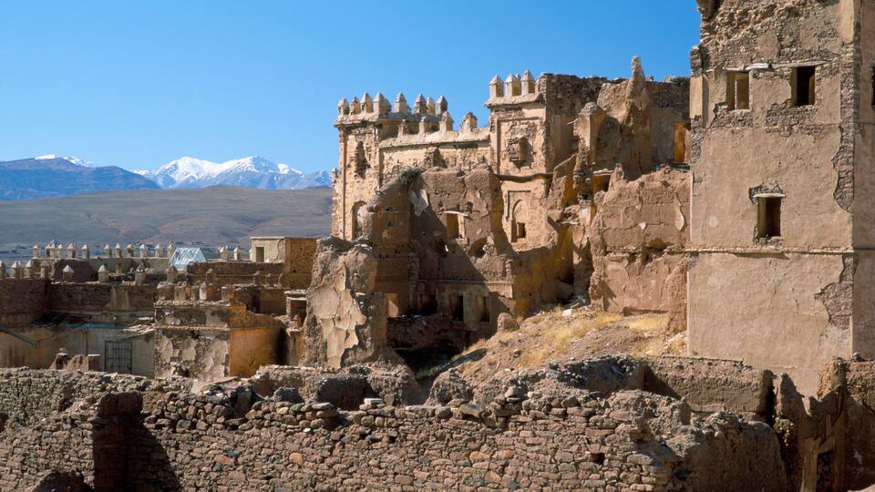 Ancient ruins with a mountainous backdrop.