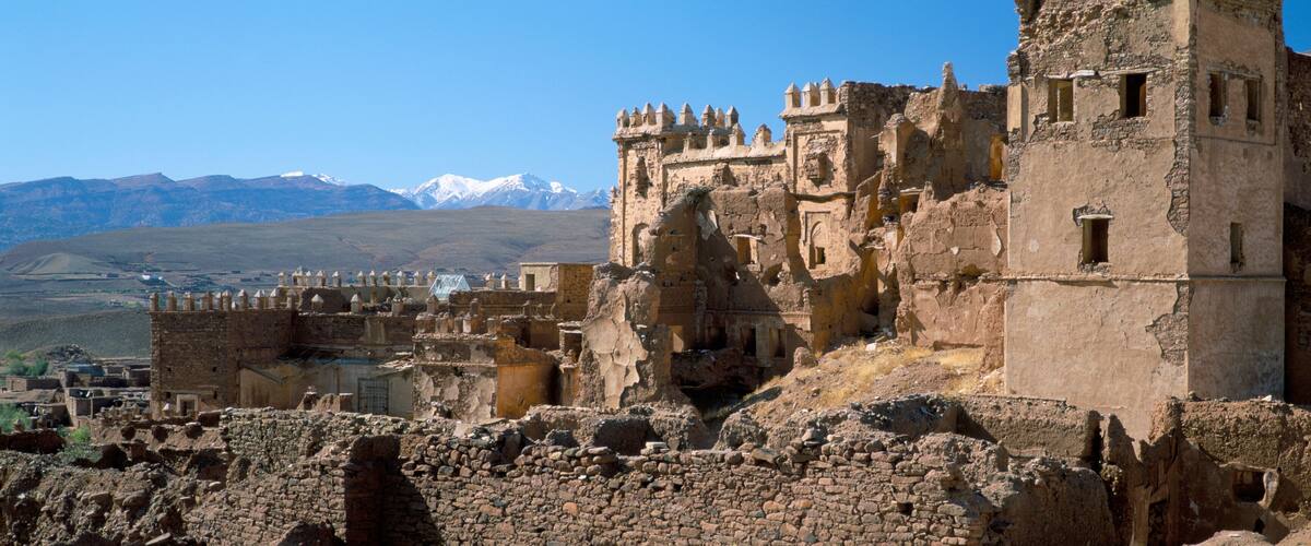 Ancient ruins with a mountainous backdrop.