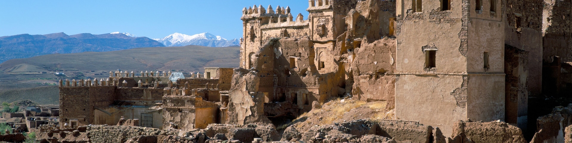 Ancient ruins with a mountainous backdrop.