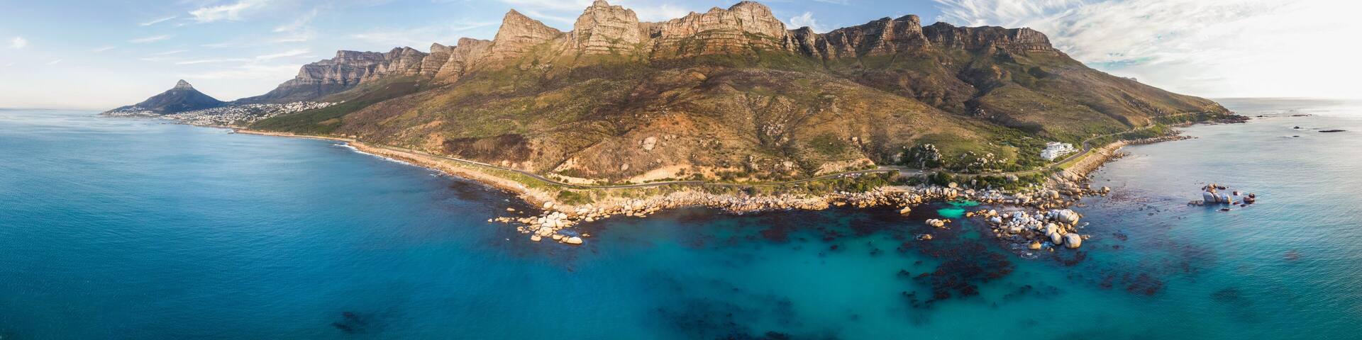 Panoramic aerial view of scenic beach road along Atlantic Ocean going past Twelve Apostles and Lions Head, Victoria Road, Oudekraal, Cape Town, South Africa