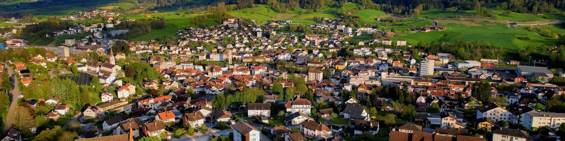 Uma cidade situada em um vale, com montanhas ao fundo.