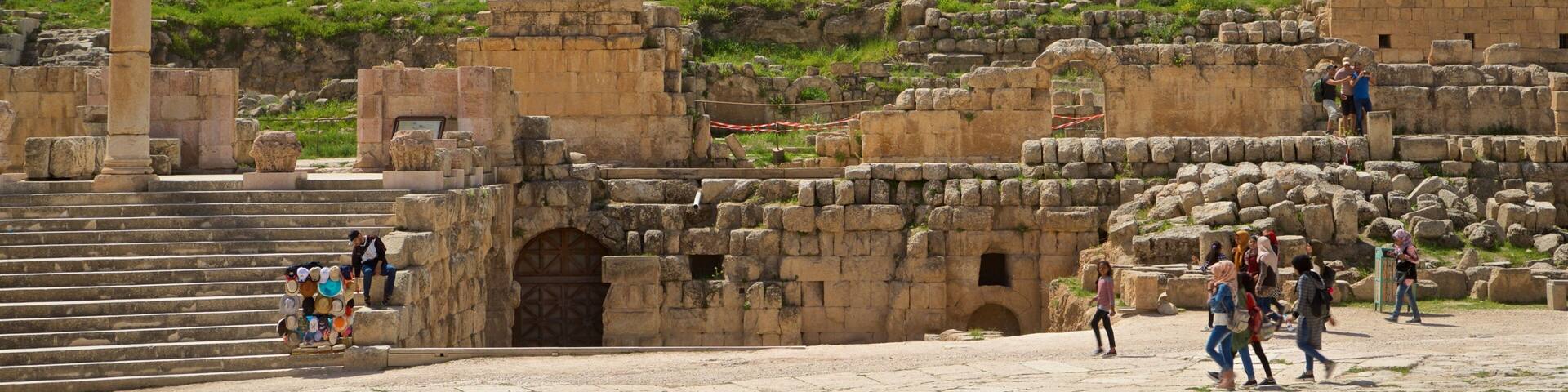Jerash showing heritage architecture and a ruin as well as a small group of people