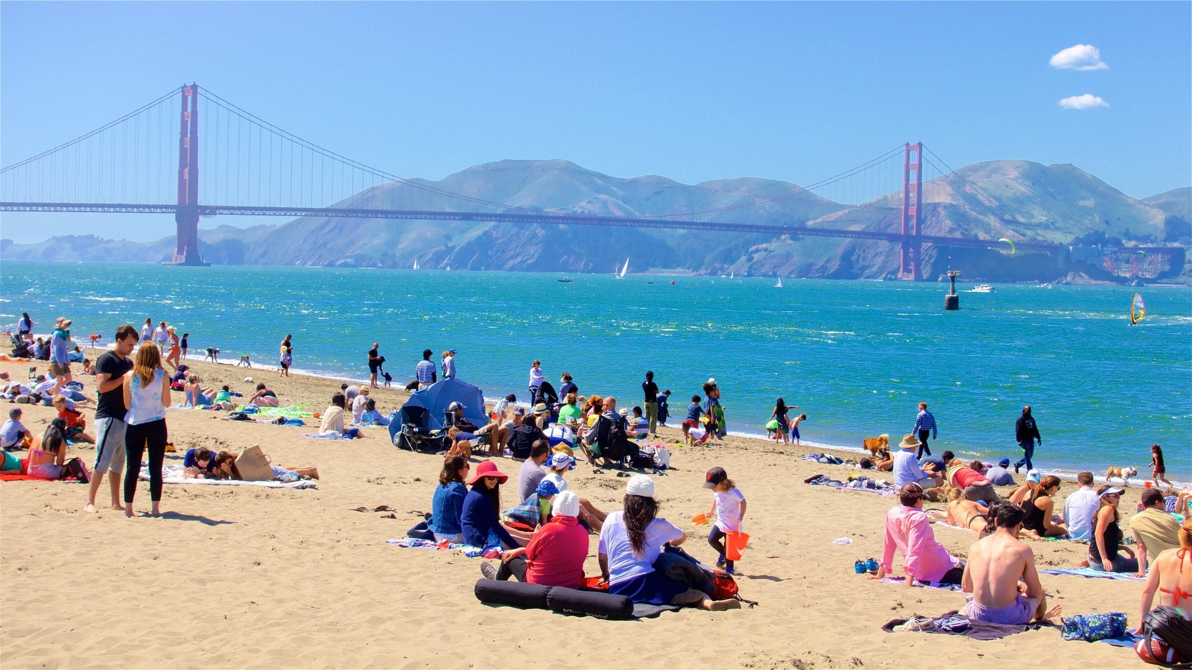 Crissy Field showing a sandy beach and general coastal views as well as a large group of people