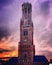 Una torre histórica con un reloj, al frente de un cielo con una puesta de sol espectacular.