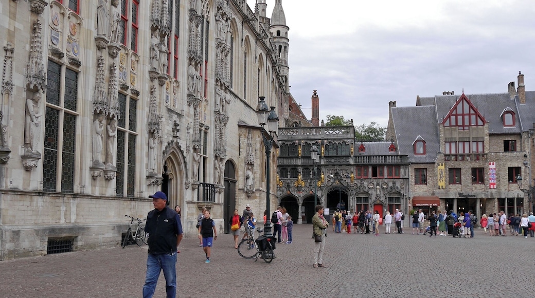 Bruges City Hall to the left & the Gothic exterior of the Basilica of Holy Blood with gilded figures in the corner of this charming square.
Bruges’ City Hall dates from 1376 and is one of the oldest in the Low Countries. It is from here that the city has been governed for more than 600 years.
Basilica of the Holy Blood dates from the 12th century.