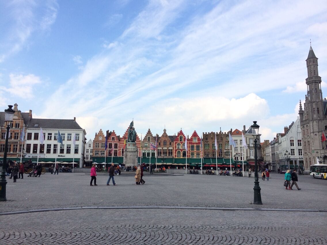 Una plaza adoquinada con edificios históricos y una estatua.