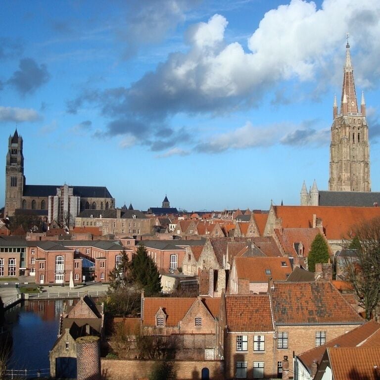 Une ville historique, avec un clocher d’église imposant et une cathédrale en arrière-plan.