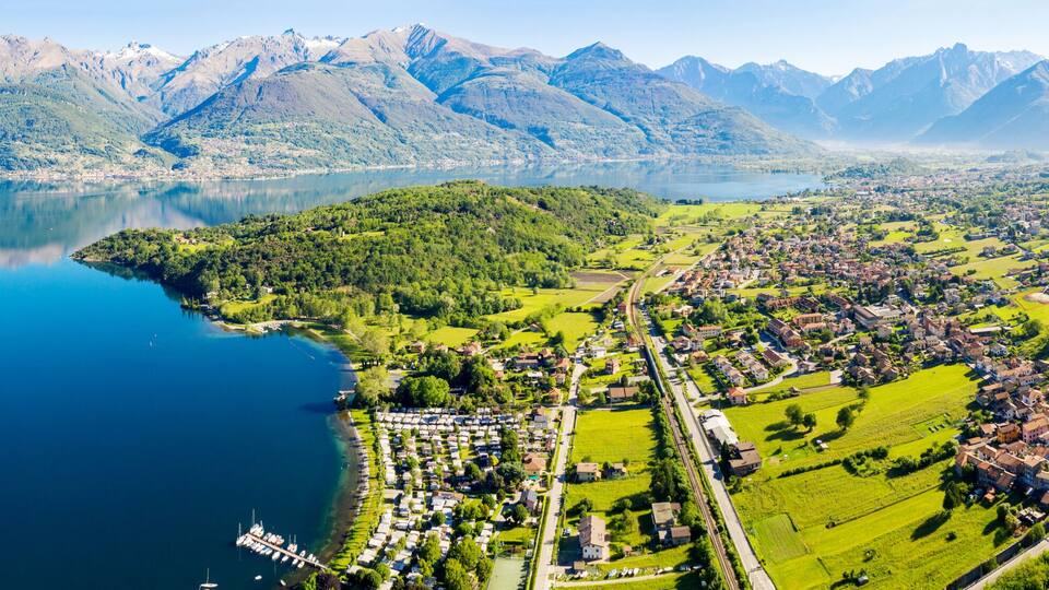 A lake surrounded by mountains, a small village, and a marina.
