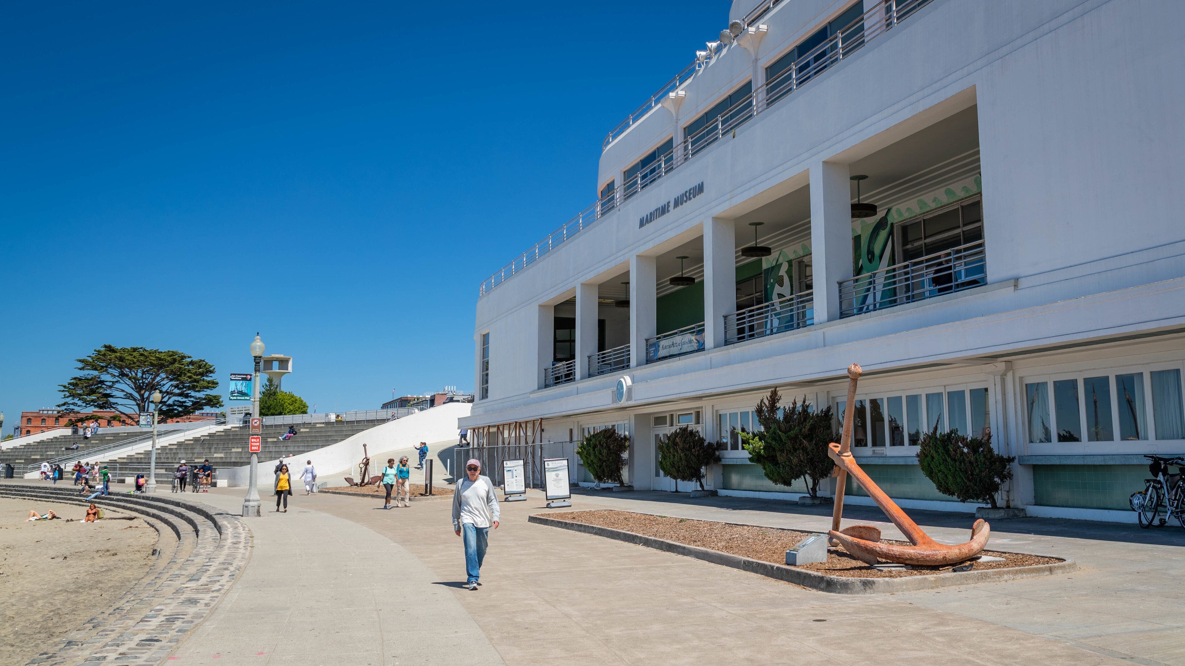 A waterfront promenade with a Maritime Museum, a large ship sculpture, and a staircase leading to a viewing platform.