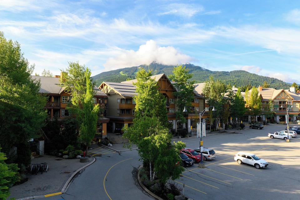 A mountain lodge with multiple buildings, a parking lot, and a road curving around the property.