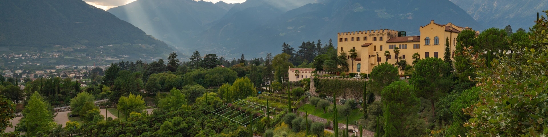 Un castillo rodeado de exuberante vegetación y montañas.