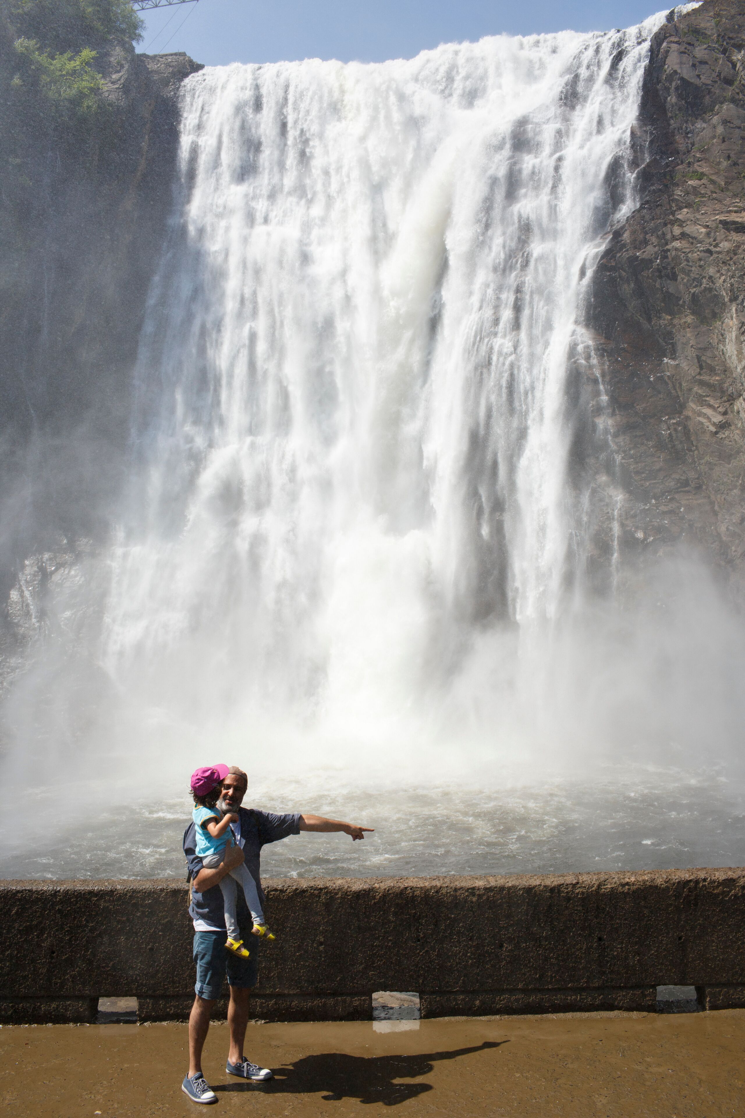 father and kid in front of Montmorency waterfalls in Quebec City