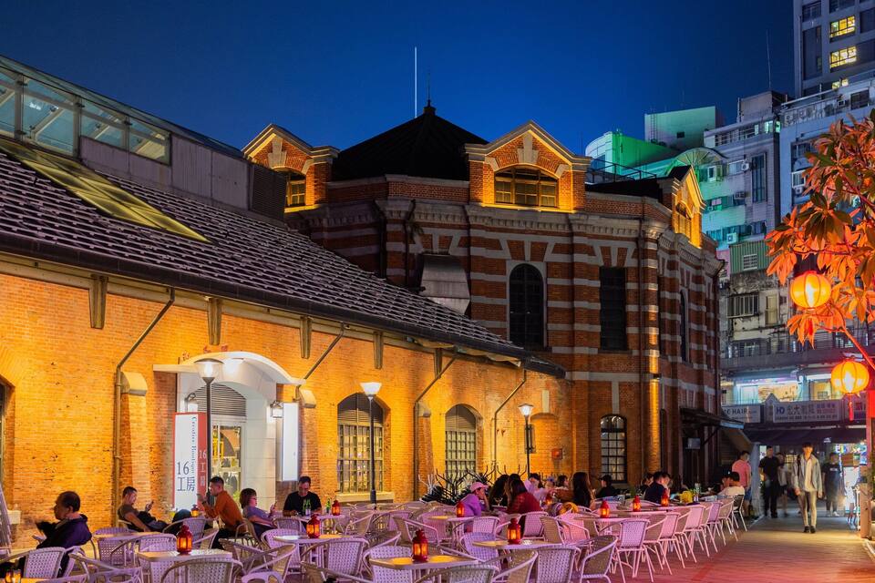 An outdoor café with brick buildings and tables.