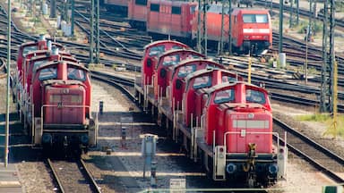 Ein Rangierbahnhof mit mehreren roten Zügen, die auf parallelen Gleisen abgestellt sind.