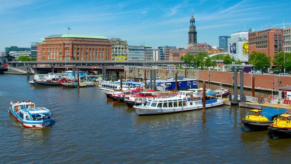 A harbor with boats docked, a bridge, and historic buildings in the background.