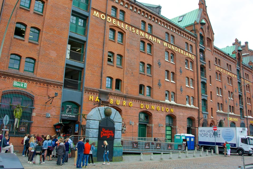 A historic building with the sign "Modelleisenbahn Wunderland" and "Hamburg Dungeon" on its facade.