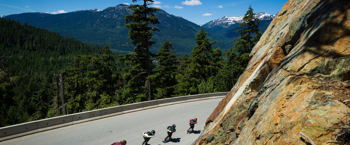 Whistler Sliding Centre featuring mountains and street scenes as well as a small group of people