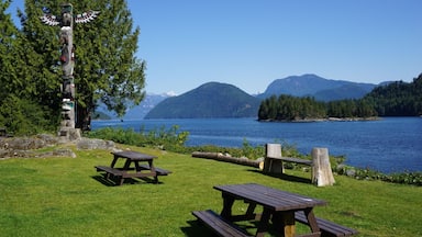 Zona de picnic junto al lago con bancos de madera y un tótem.