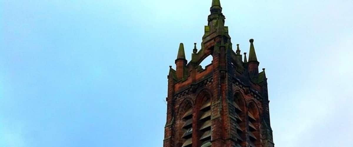 A large, historic brick church with a tall tower and arched windows.