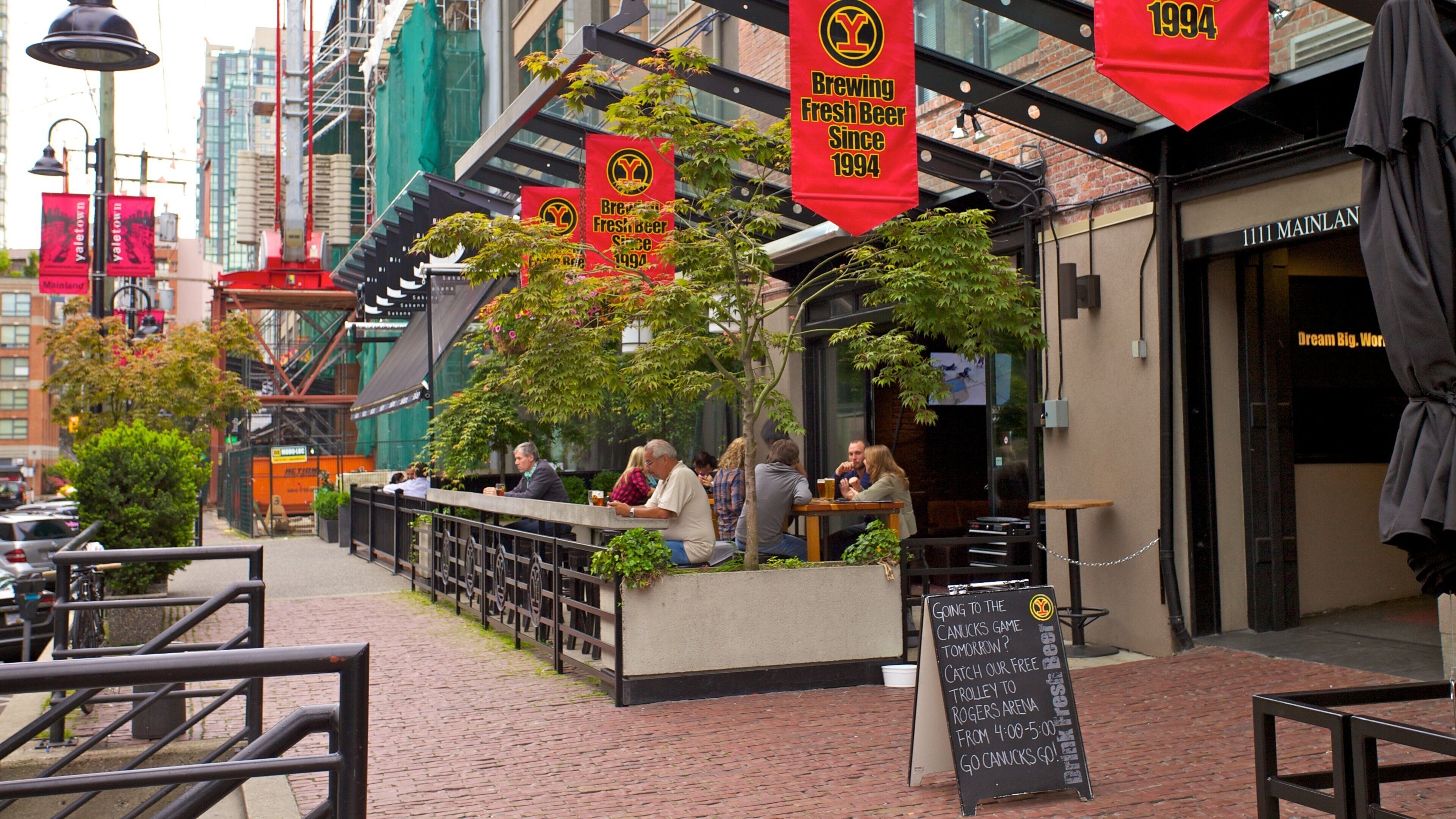 Vibrant street life in Yaletown, Vancouver, showcasing local cafes and outdoor dining along a charming urban walkway