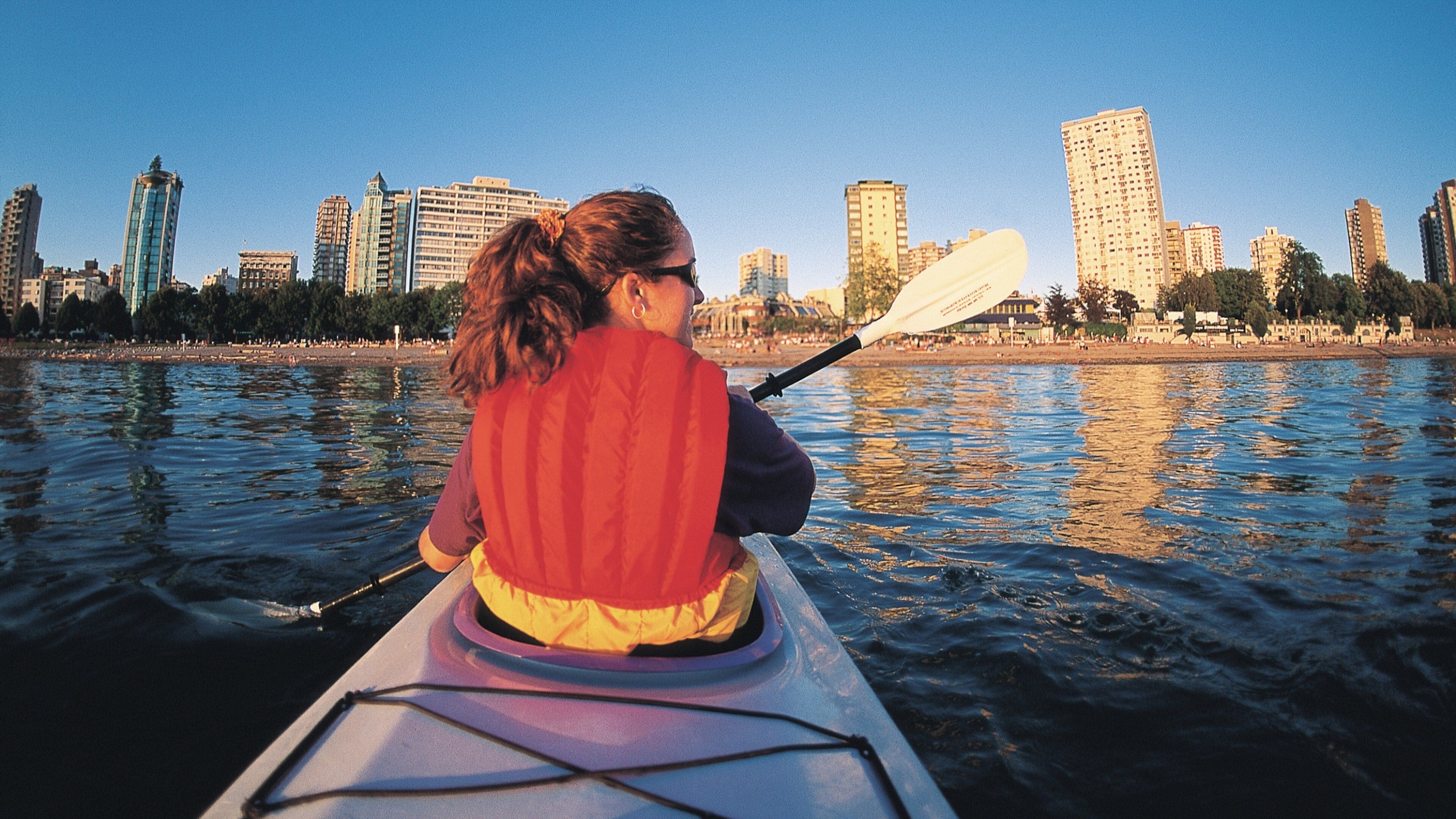 Exploring English Bay near Inukshuk at sunset while kayaking in Vancouver, British Columbia