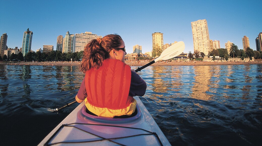 English Bay Inukshuk which includes kayaking or canoeing, a skyscraper and a bay or harbor
