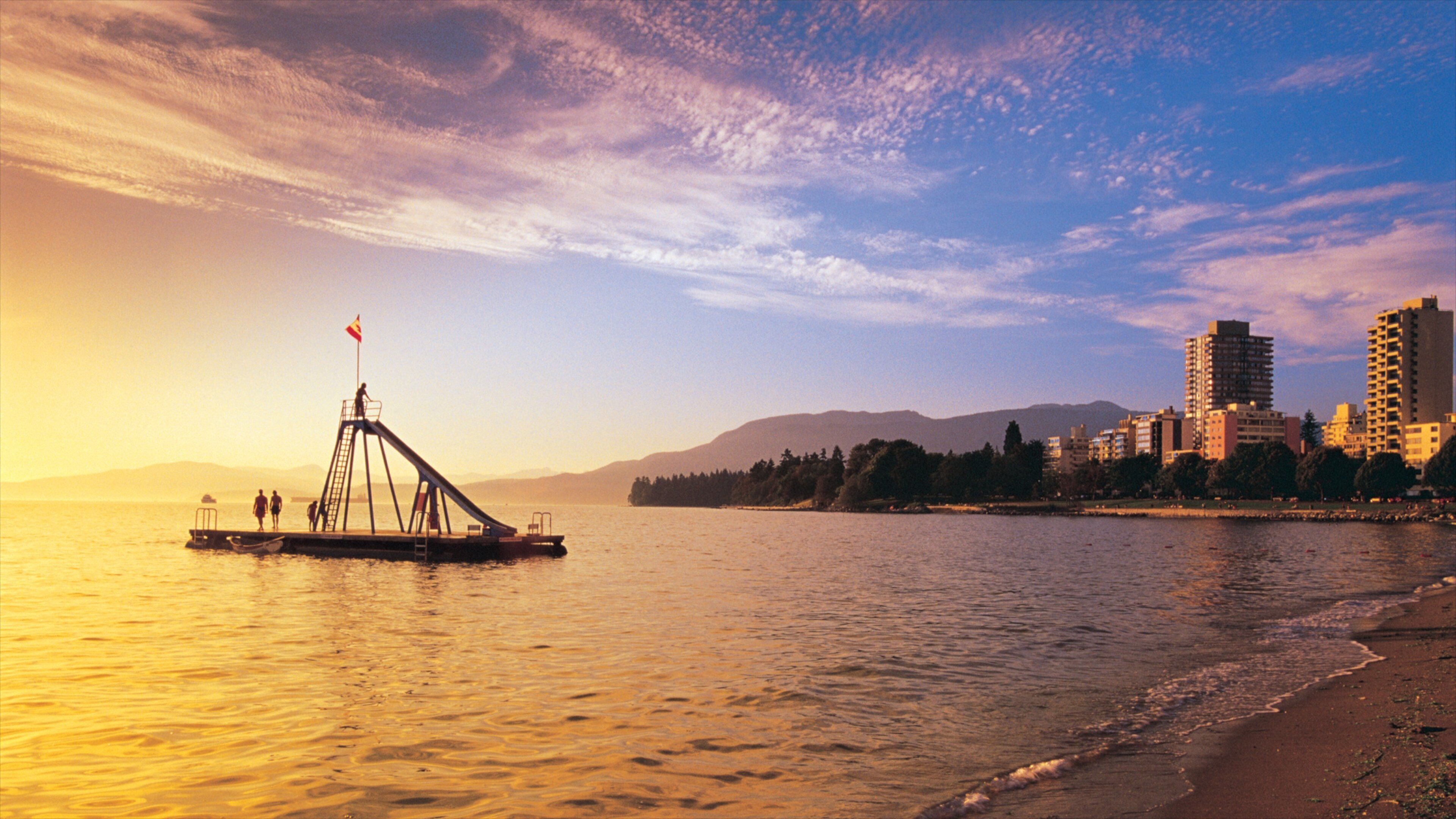 Quiet sunset over English Bay Inukshuk with city skyline in Vancouver, British Columbia