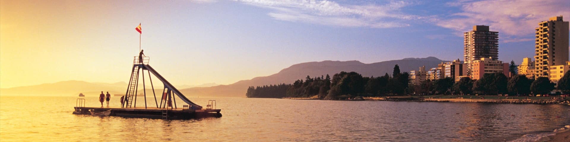 Quiet sunset over English Bay Inukshuk with city skyline in Vancouver, British Columbia