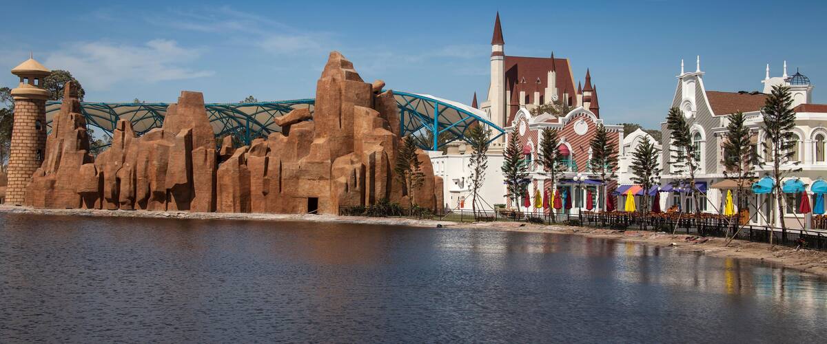 A roller coaster, a castle, and a body of water.