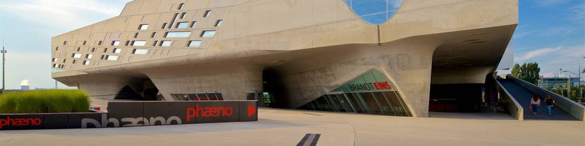 A modern architectural building with a unique angular design, featuring a glass facade and a prominent entrance.