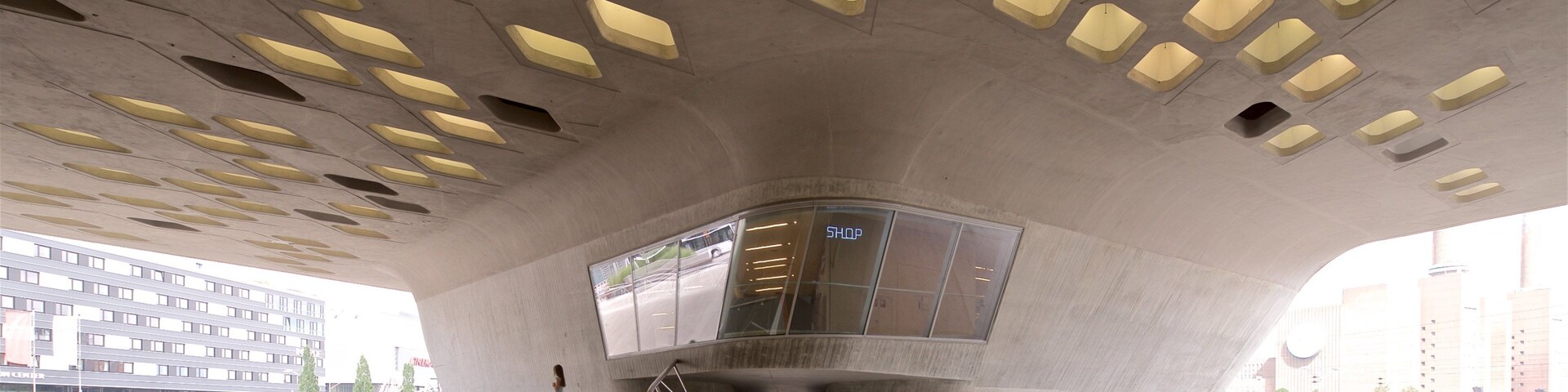 Una estructura arquitectónica moderna con un diseño de techo único y una escalera central.