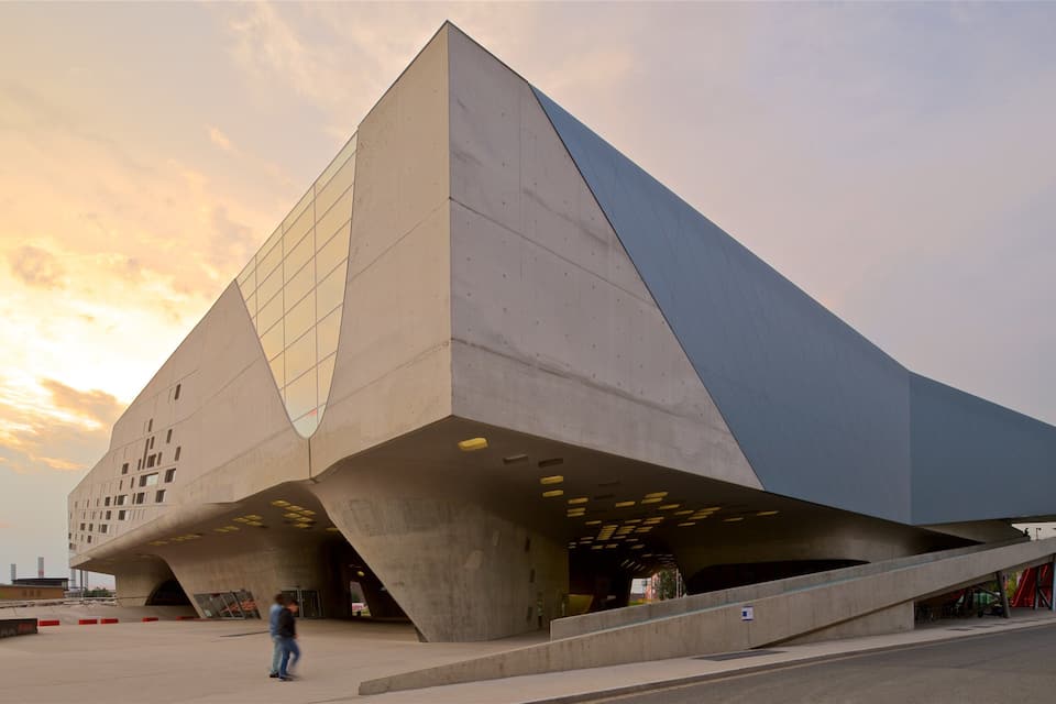 A modern architectural building with a triangular design and a sloped roof.