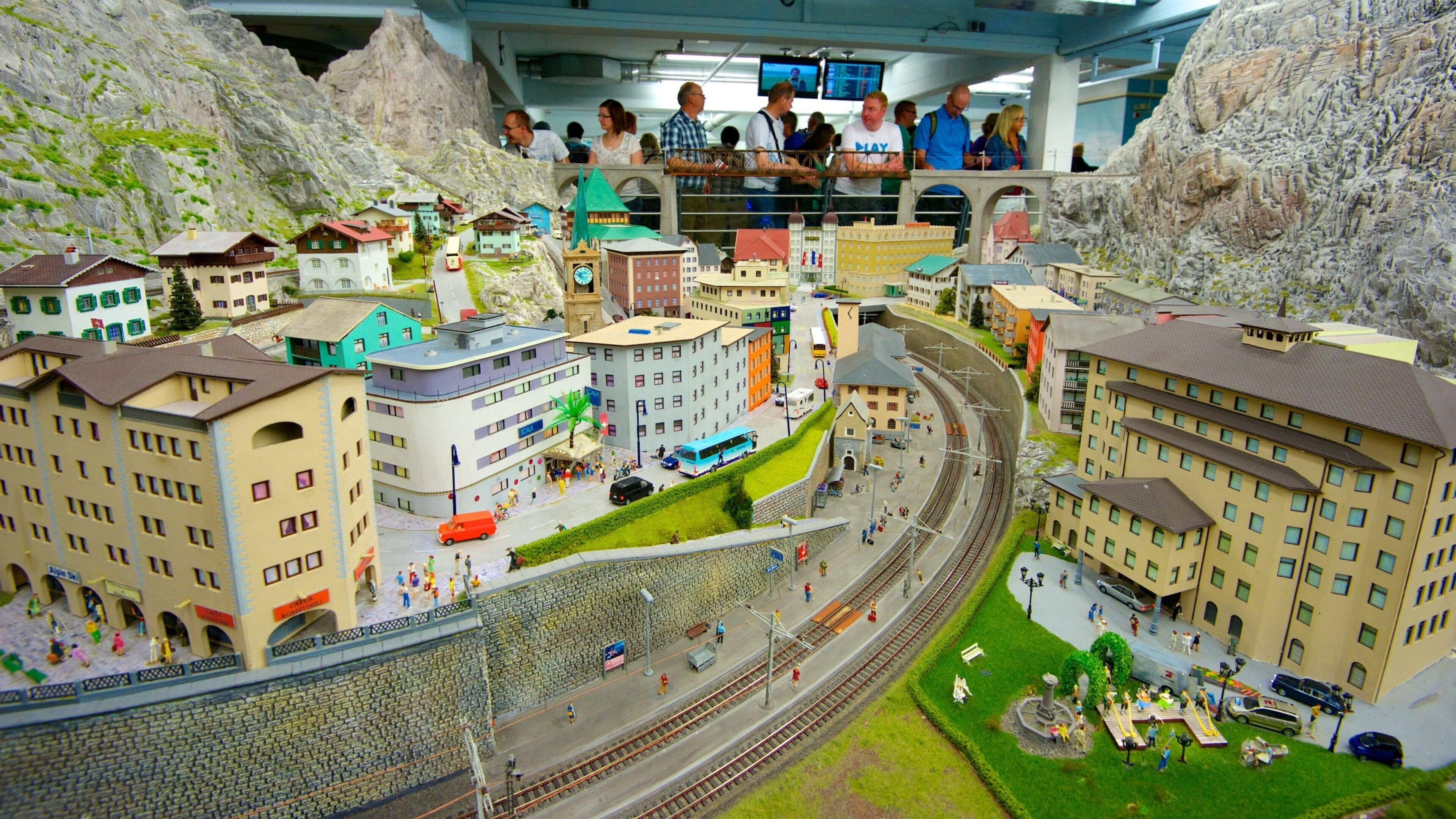 Een gedetailleerd model van een stad met gebouwen, wegen en een treinrails.