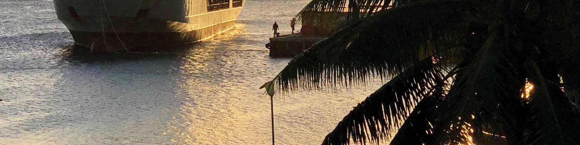 A container ship arrives at sunset in the Port of Refuge, Neiafu, Tonga.