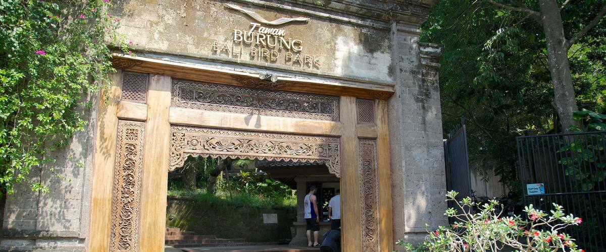 An ornate entrance to Taman Burung Bird Park with intricate carvings and a sign above.