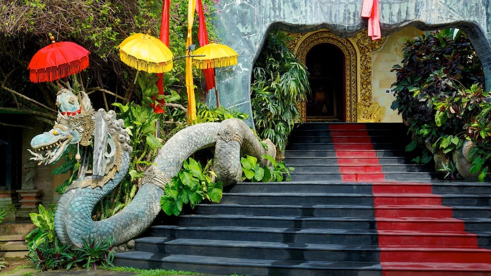 A staircase with a dragon sculpture, red and yellow umbrellas, and lush greenery.