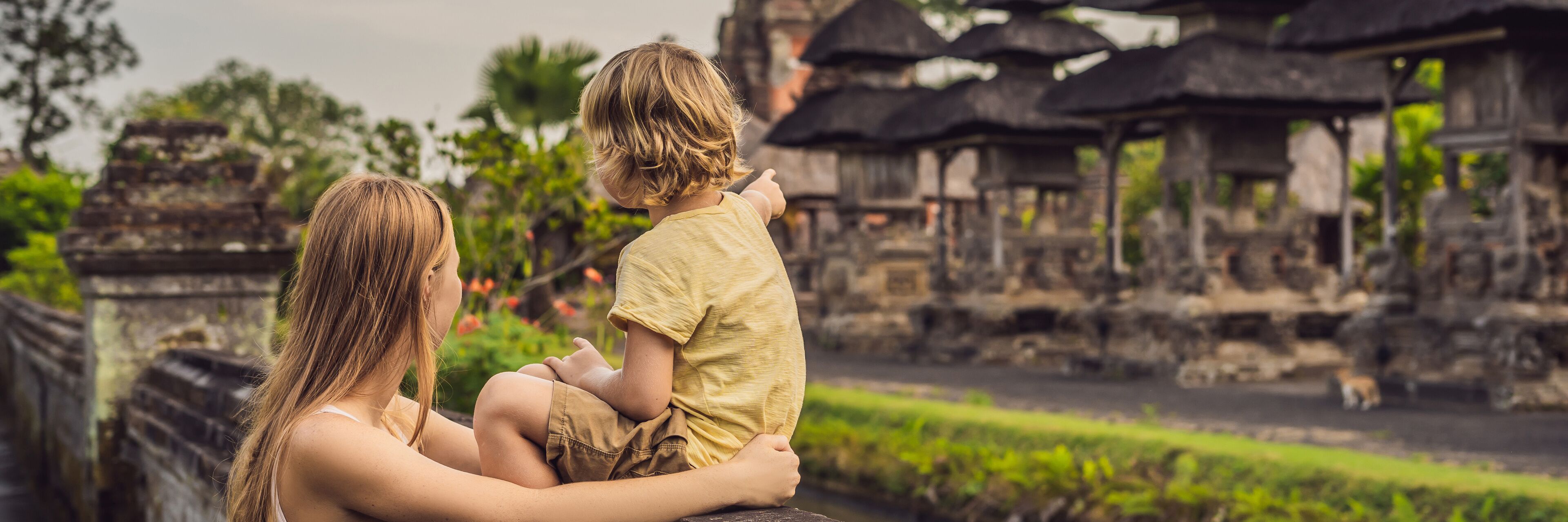 Mom and son tourists in Traditional balinese hindu Temple Taman Ayun in Mengwi. Bali, Indonesia Traveling with children concept BANNER, long format