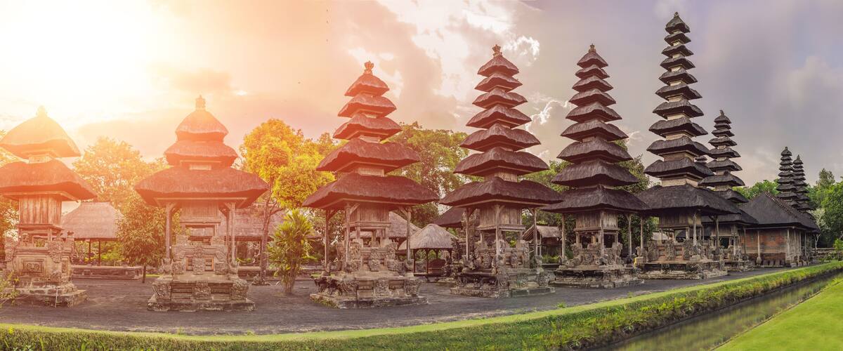 A temple complex with multiple pagodas and thatched-roof structures.