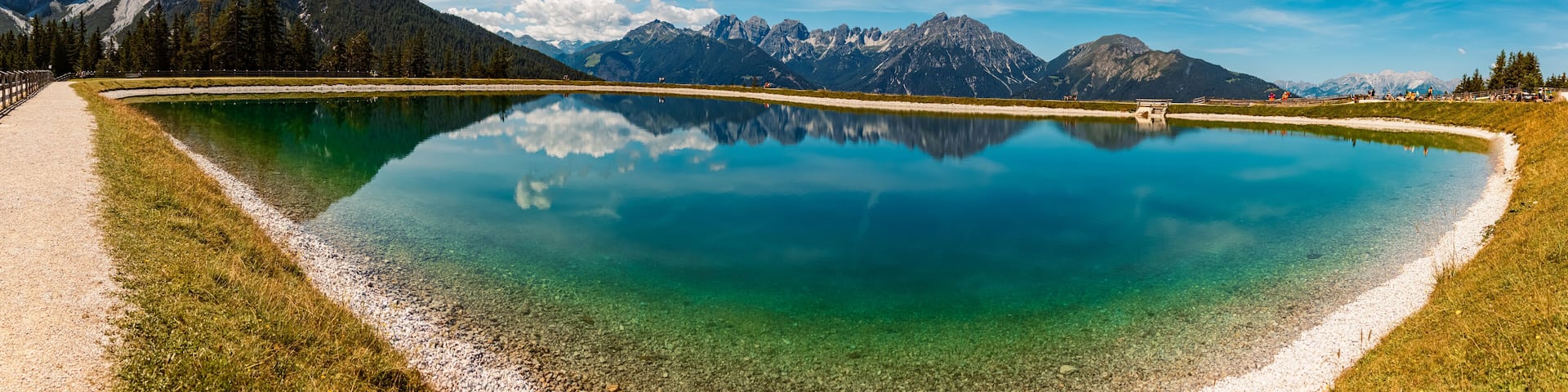 High resolution stitched alpine summer panorama with reflections in a lake at Serles cable car station, Mieders, Stubaital valley, Innsbruck, Austria